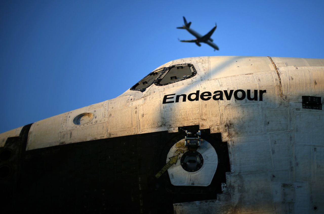 A plane flies over the space shuttle Endeavour as it is moved to the California Science Center on Saturday.