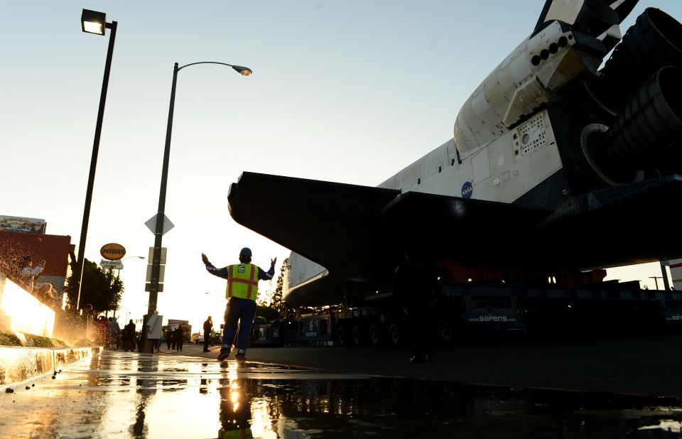 A worker accompanies the space shuttle Endeavour along Manchester Boulevard. 