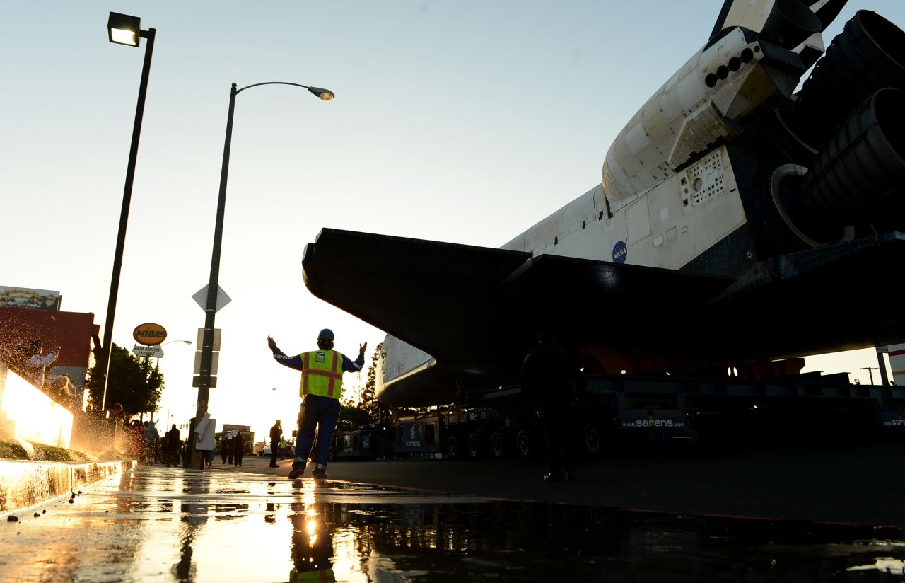A worker accompanies the space shuttle Endeavour along Manchester Boulevard.