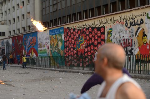 Egyptian opponents of the Muslim Brotherhood and President Mohamed Morsy throw a Molotov cocktail toward government supporters on Friday.