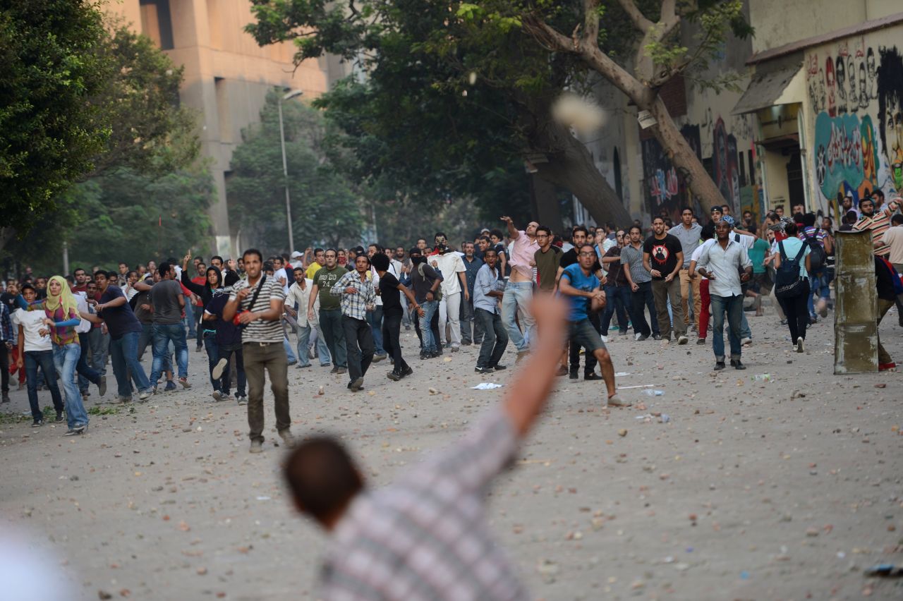 Protesters and government supporters throw stones at each other during clashes on Friday.