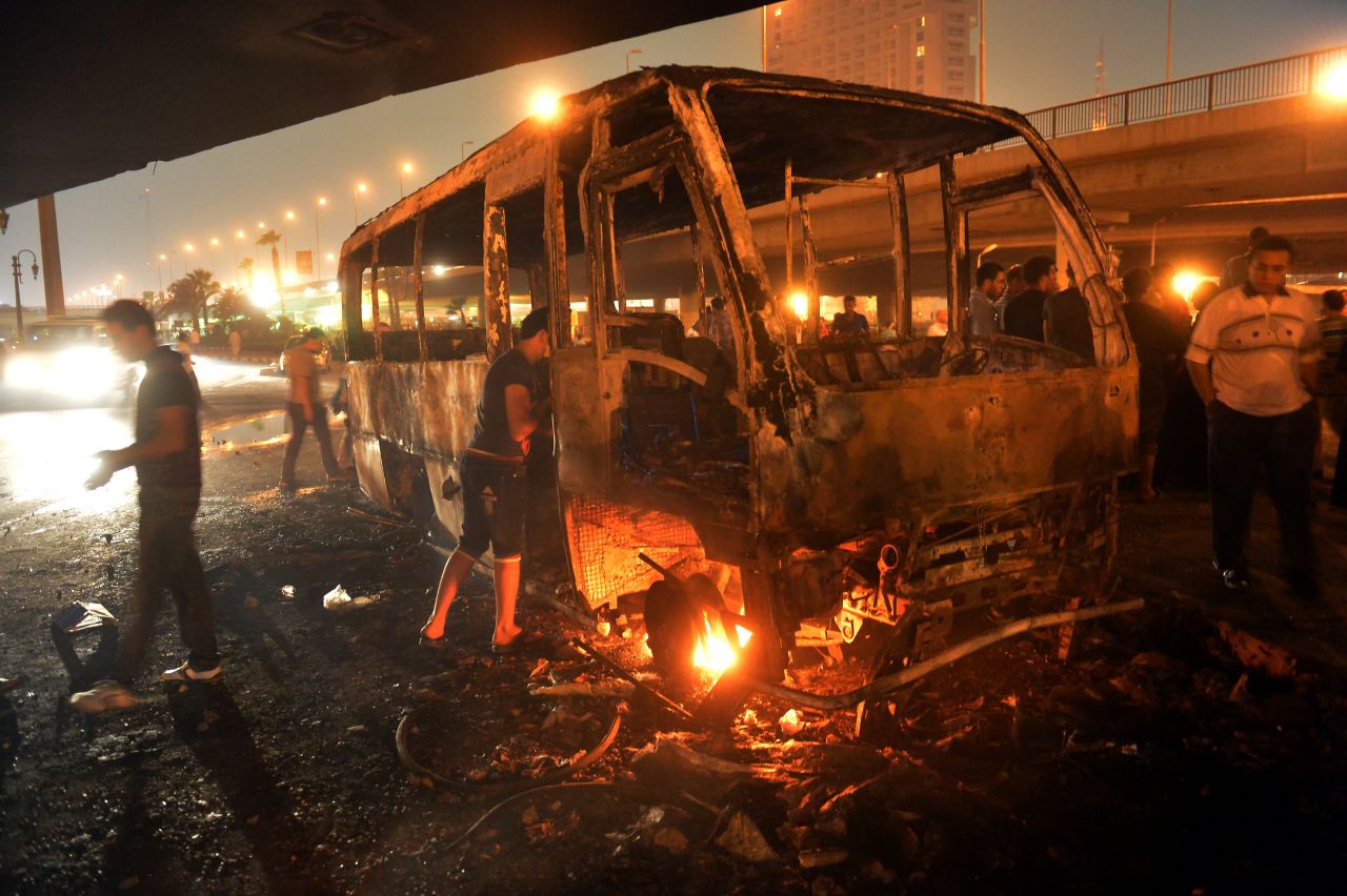 Egyptians inspect a bus that was set on fire during clashes between government supporters and opponents of the Muslim Brotherhood and President Mohamed Morsy.