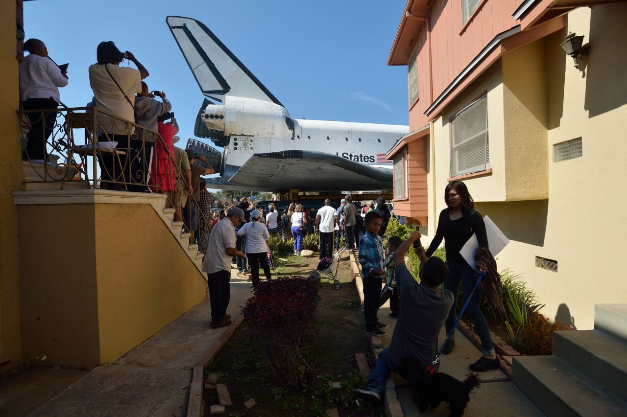 People watch Endeavour pass residential buildings on Crenshaw Drive. Over two days, the 170,000-pound shuttle will travel at no more than 2 mph along a 12-mile route from Los Angeles International Airport to its final home.