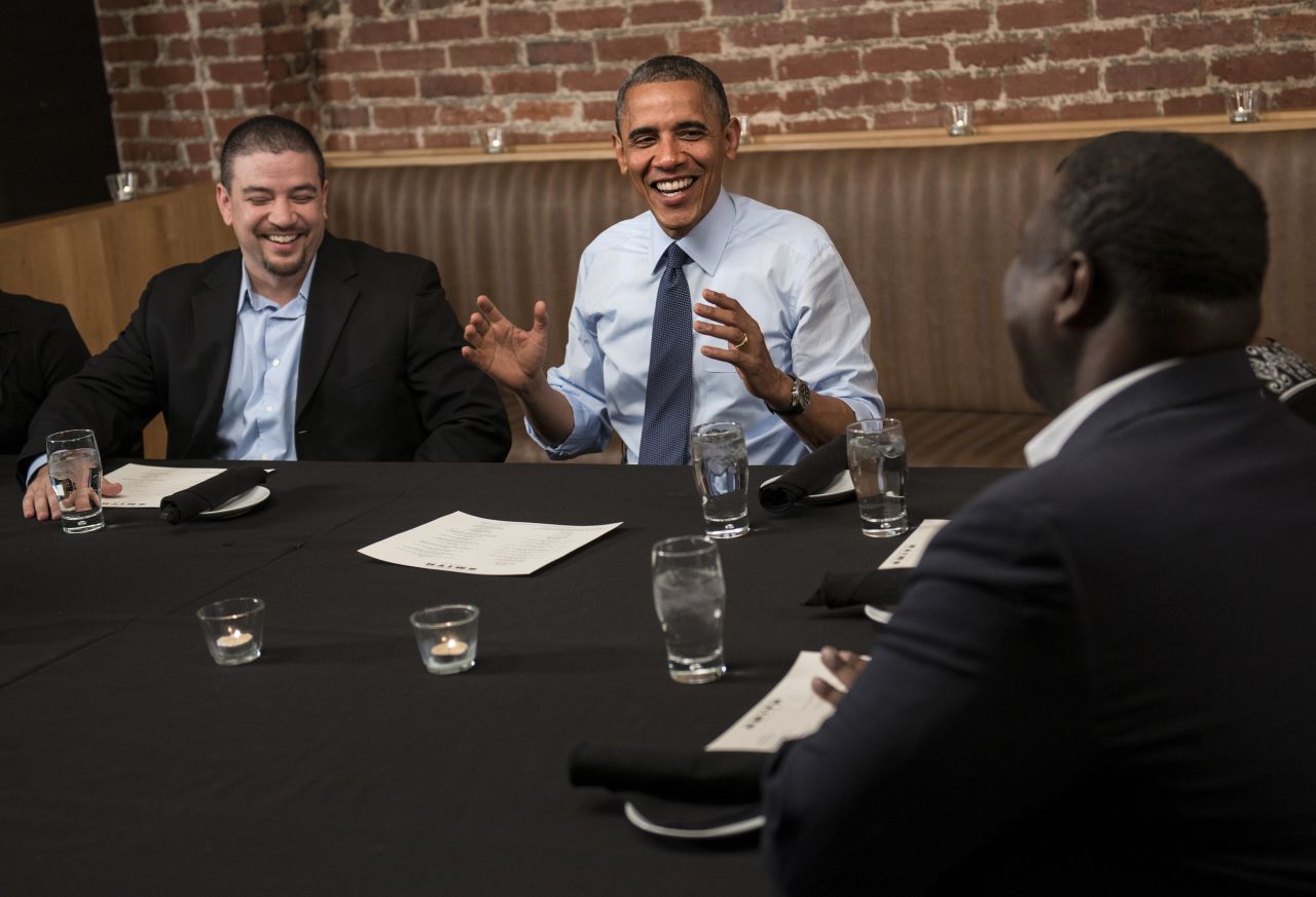 Mario Orosa, left, and Ron Cathey, right, chat with Obama during dinner at Smith Commons restaurant in Washington on Friday, October 12. Obama had dinner with contest winners who contributed to his re-election campaign. 