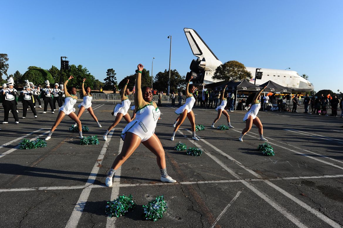 Inglewood High School cheerleaders perform near the shuttle on Saturday.