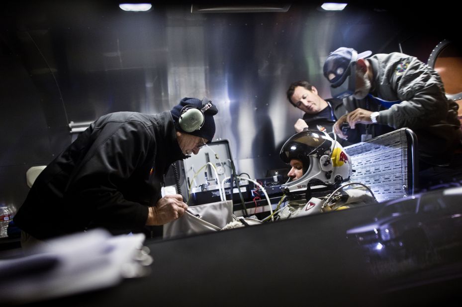 Crew members assist Baumgartner in his trailer. The Red Bull Stratos team includes a former NASA crew surgeon, record-breaking aviators and innovative aircraft designers.