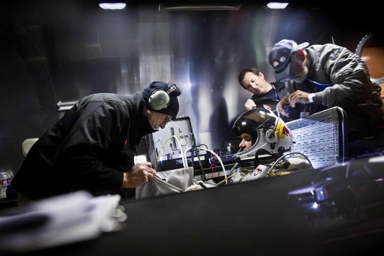 Crew members assist Baumgartner in his trailer. The Red Bull Stratos team includes a former NASA crew surgeon, record-breaking aviators and innovative aircraft designers.