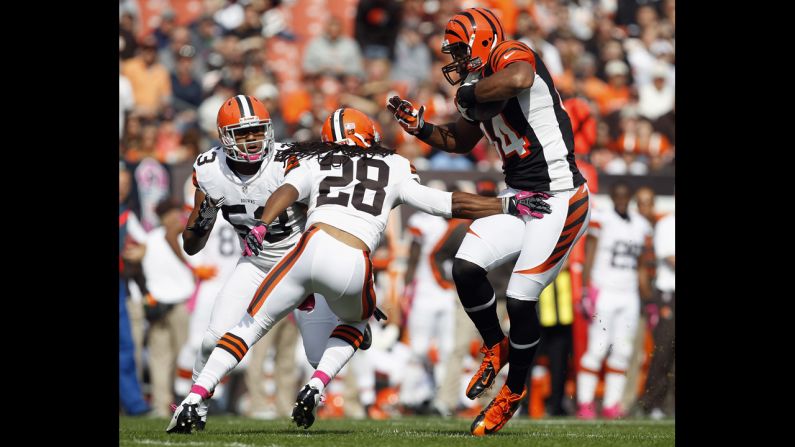 Jermaine Gresham of Cincinnati catches a touchdown pass as he avoids tackles by Cleveland defenders on Sunday.