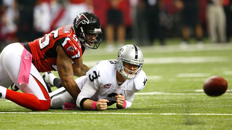 John Abraham of the Atlanta Falcons forces a fumble and turnover by Carson Palmer of the Oakland Raiders on Sunday at the Georgia Dome in Atlanta.
