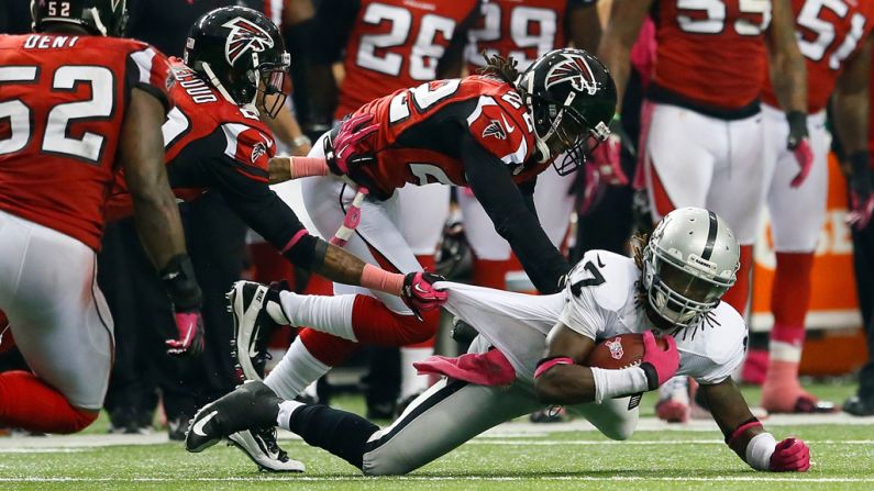Denarius Moore of the Raiders is tackled by Falcons defenders on Sunday.,