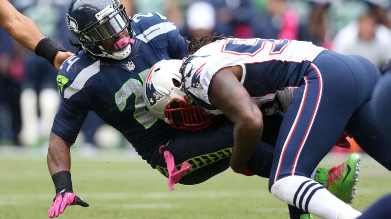 Marshawn Lynch of the Seahawks is tackled by Brandon Spikes of the Patriots.