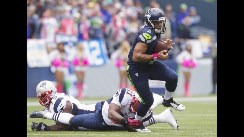 Russell Wilson of the Seattle Seahawks escapes the grasp of the Patriots' Jerod Mayo.