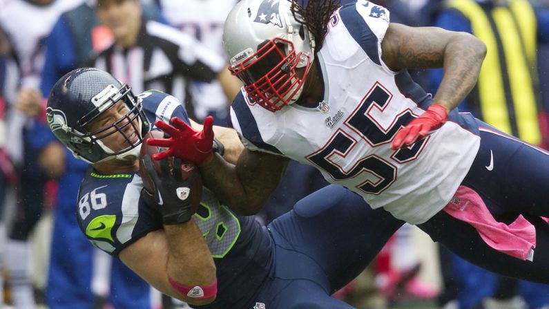 Zach Miller of the Seattle Seahawks pulls in a pass while being defended by Brandon Spikes of the New England Patriots.