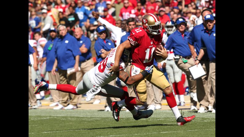 San Francisco 49ers quarterback Alex Smith runs the ball for a gain as Michael Boley of the New York Giants makes the tackle.