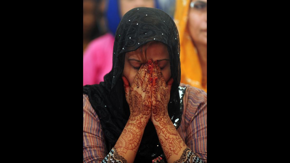 A Pakistani female covers her face during prayers in Karachi.