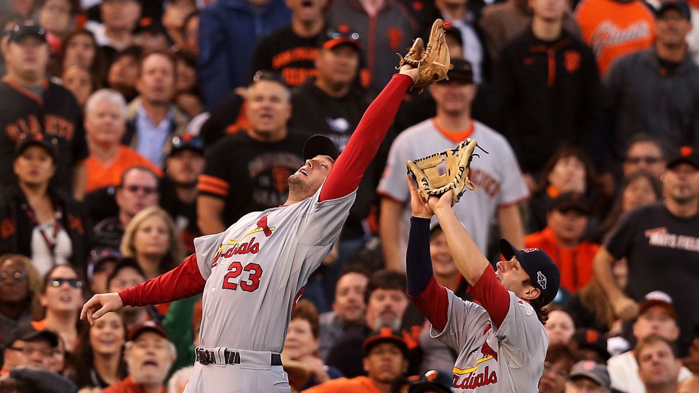 David Freese of the Cardinals catches a fly ball over teammate Pete Kozma to end the third inning of Game One.
