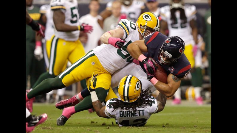 Owen Daniels of the Texans is tackled by A.J. Hawk, left, and Morgan Burnett of the Packers.