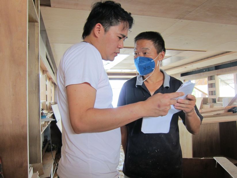 Samuel Wong, left, gives directions to one of his employees.