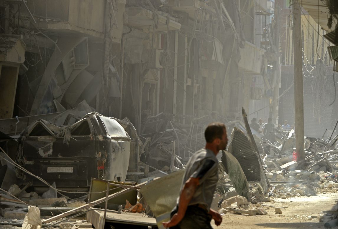 A Syrian man walks past destroyed buildings following shelling by regime forces in Aleppo on Monday, October 15. 