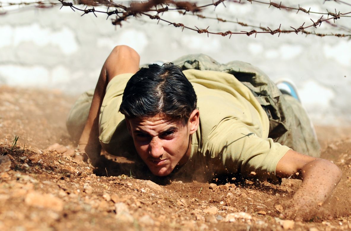 A Free Syrian Army fighter climbs under barbed wire as he trains at their camp in Syria's northwestern province of Idlib in an area under the control of rebel fighters on Monday.