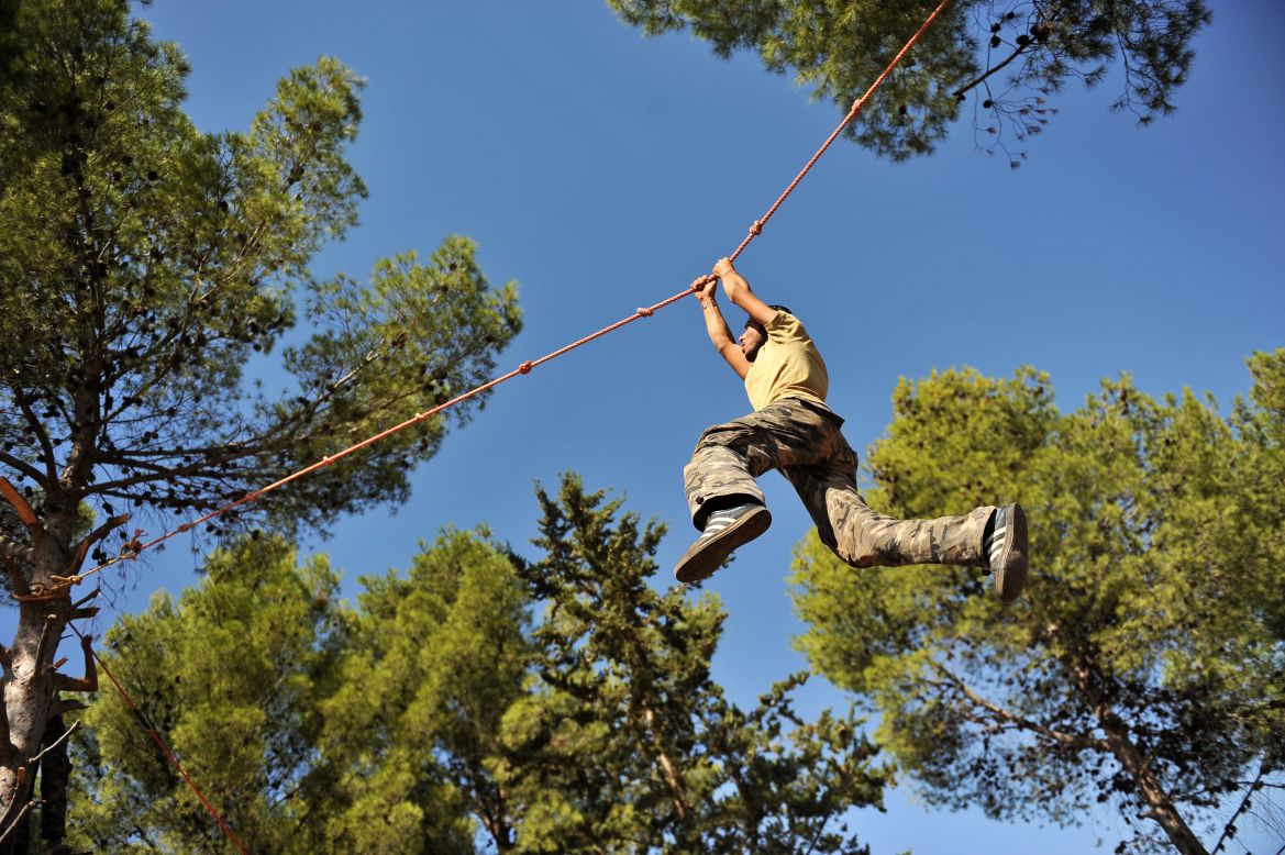 A young fighter climbs along a rope as he trains at a Free Syrian Army camp in Syria's northwestern province of Idlib on Monday.