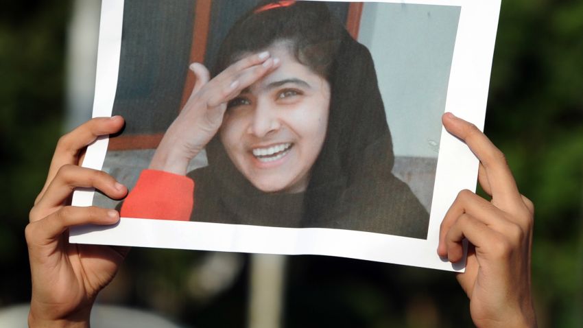 A Pakistani female activist of an Islamic Minhaj-ul-Quran Party holds a photograph of child activist Malala Yousafzai during a protest against the assassination attempt by Taliban, in Islamabad on October 13, 2012. A Pakistani schoolgirl shot in the head by the Taliban remained on a ventilator in hospital Saturday, as people continued to pray for her recovery, the military said.