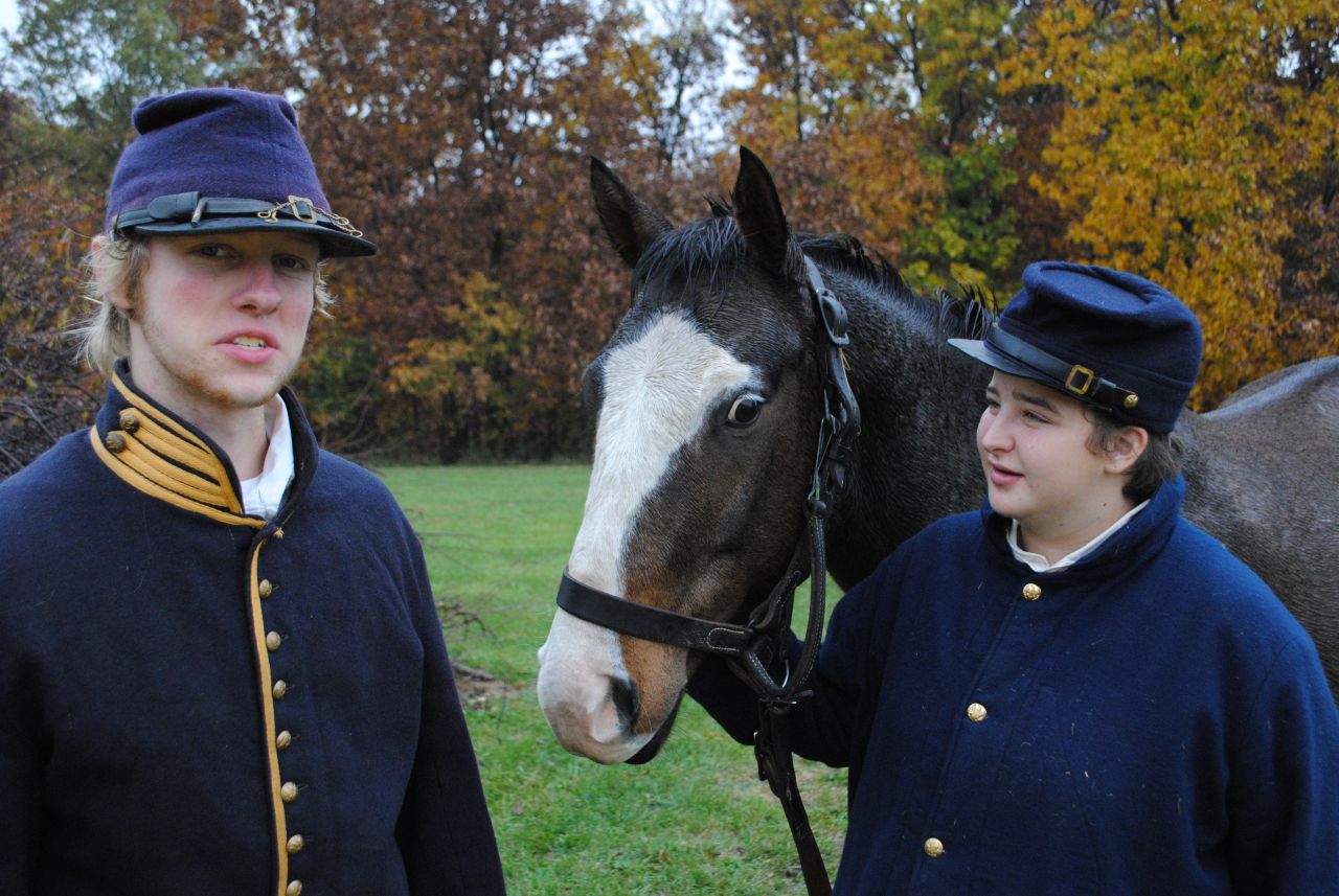 Not just a generational thing: Two teenage re-enactors watch their horse on the battleground