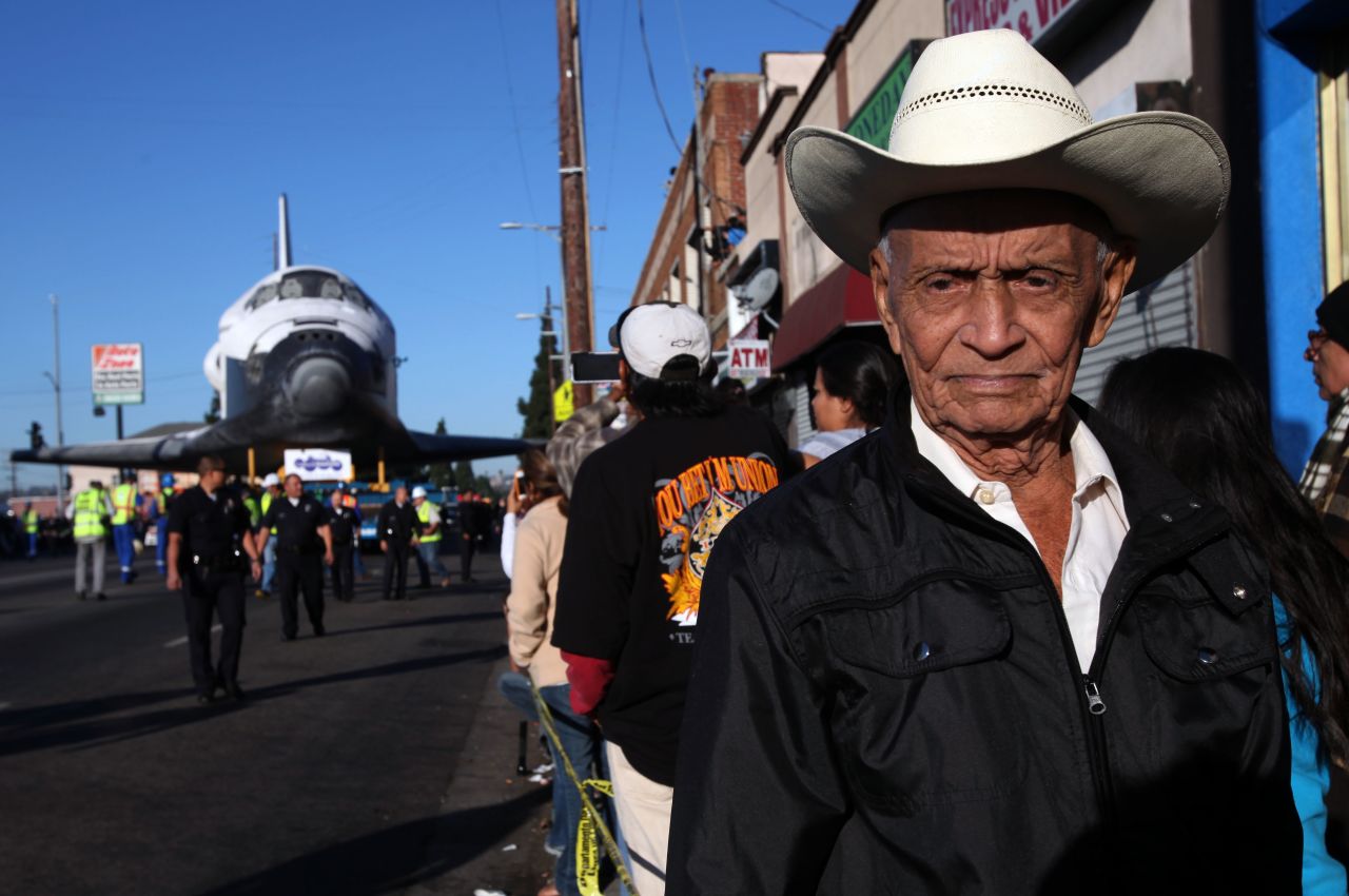 Federico Gonzales is among the many spectators as Endeavour inches down Martin Luther King Boulevard in Los Angeles on Sunday.