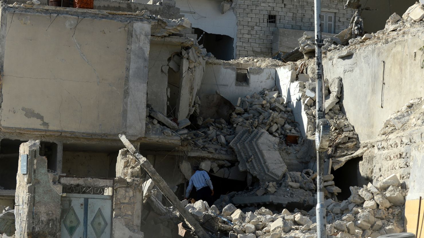 A man inspects a destroyed building following shelling by regime forces in the northern city of Aleppo on Monday.