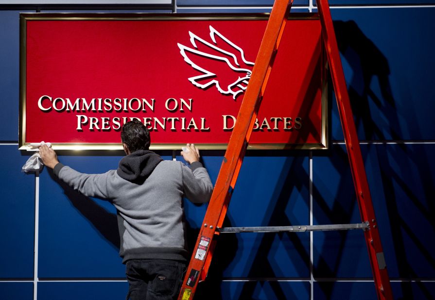 A worker cleans a sign for the Commission on Presidential Debates before the second presidential debate in Hempstead, New York, on Tuesday.