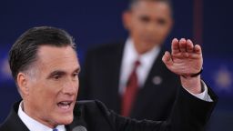 Romney gestures to make a point as President Obama looks on.