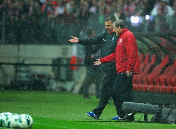 England manager Roy Hodgson speaks to a member of the Polish coaching staff as the rain continues to fall in Warsaw with the surface deemed to be unplayable.