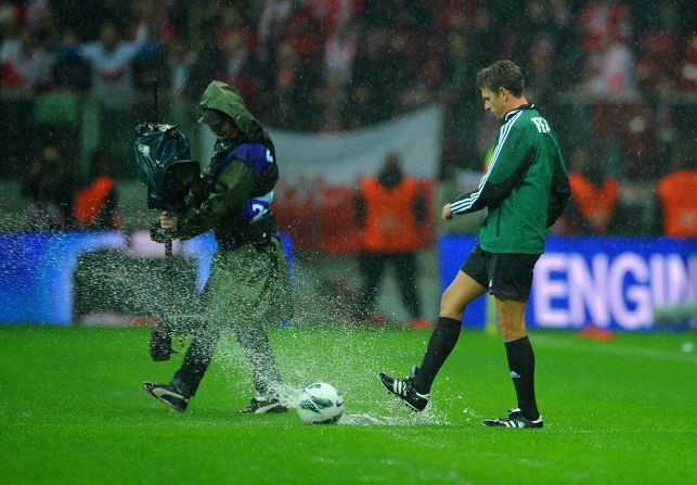 Match referee Gianluca Rocchi tests out the sodden turf but any thoughts of play were soon abandoned with the ball refusing to roll.