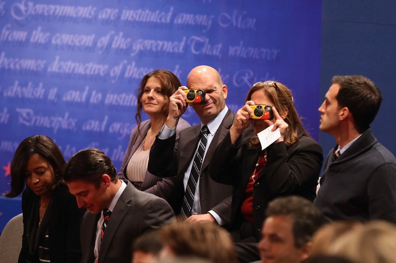 Audience members take photographs while they wait for the debate to begin.