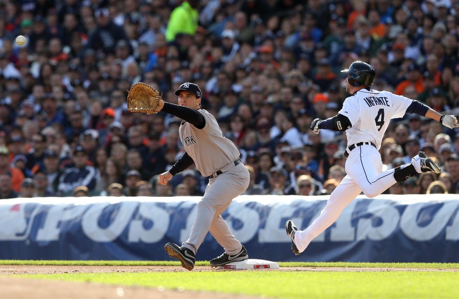 Mark Teixeira of the New York Yankees stretches for the ball as Infante beats the throw to reach first safely.