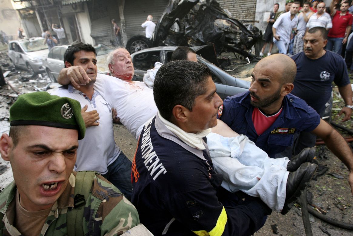 Civil defense members help a wounded man in the immediate aftermath.