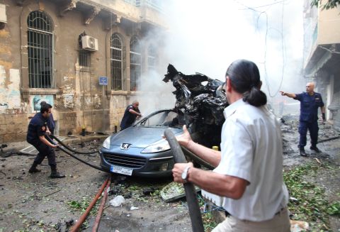 Lebanese firefighters douse burning vehicles.