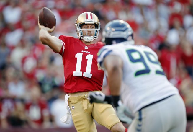 Alex Smith of the San Francisco 49ers makes a pass under pressure from defensive tackle Alan Branch of the Seattle Seahawks during the first quarter.