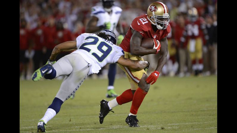 Runningback Frank Gore of the 49ers carries the ball for a 37-yard gain, breaking the tackle of Earl Thomas of the Seahawks, during the fourth quarter.