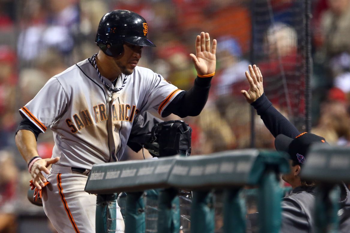 No. 7 Gregor Blanco of the Giants is congratulated at the dugout after scoring in the fourth inning against the Cardinals.