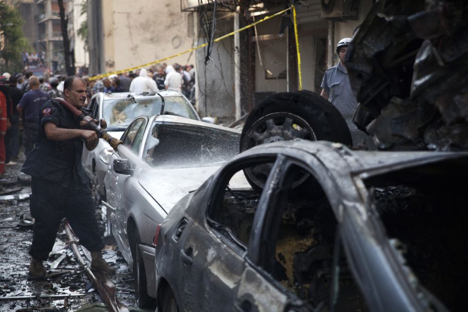 A Lebanese firefighter douses cars at the site of an explosion in Beirut's Christian neighbourhood of Ashrafieh.