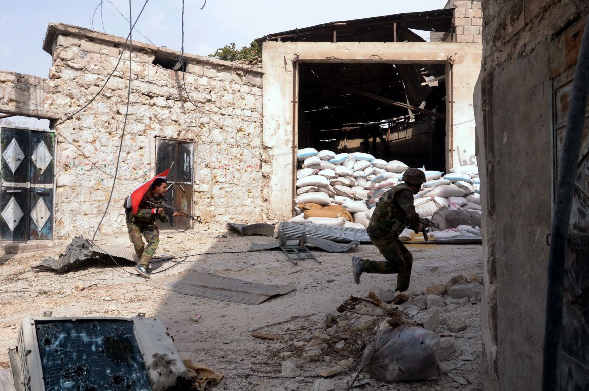 Syrian army soldiers run for cover during clashes with rebel fighters at Karam al-Jabal neighborhood of Aleppo on October 20, 2012.