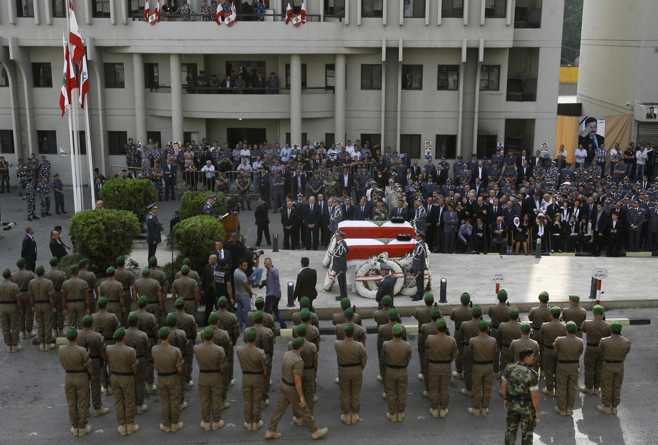 Officers and mourners gather around al-Hassan's coffin during his funeral on Sunday.
