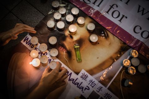 An activist with the Association for the Advancement of Feminism lights candles during a vigil in Hong Kong on Friday.