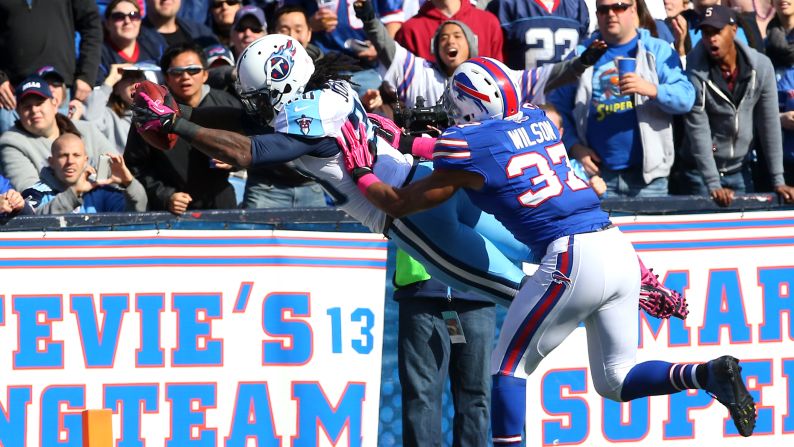 Chris Johnson of the Tennessee Titans dives in for a touchdown as George Wilson of the Buffalo Bills tries to push him out of bounds.