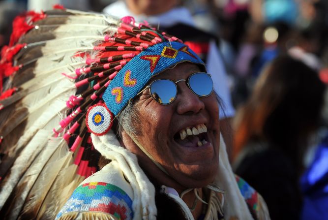 A spectator wearing a Native American headress stands in St. Peter's Square on Sunday.