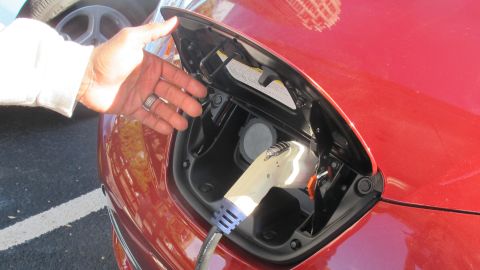 Charging an electric car is much like filling up with gas, as Randy Stanley demonstrates with his Nissan Leaf. 