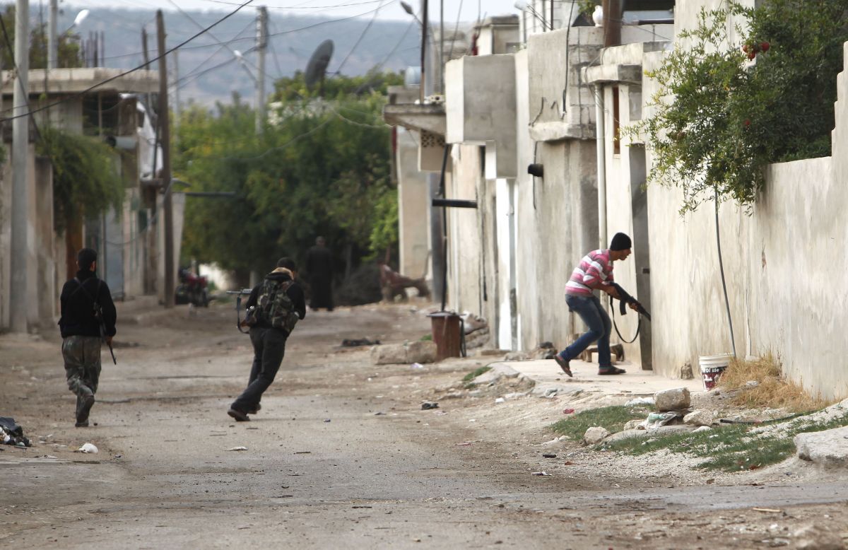  A member of the Free Syrian Army flees sniper shots from pro-government forces in Salqin, Syria, on Monday, October 22. 