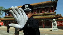 Chinese policeman blocks photos being taken outside Zhongnanhai which serves as the central headquarters for the Communist Party of China after the sacking of politician Bo Xilai in Beijing on April 11, 2012. 