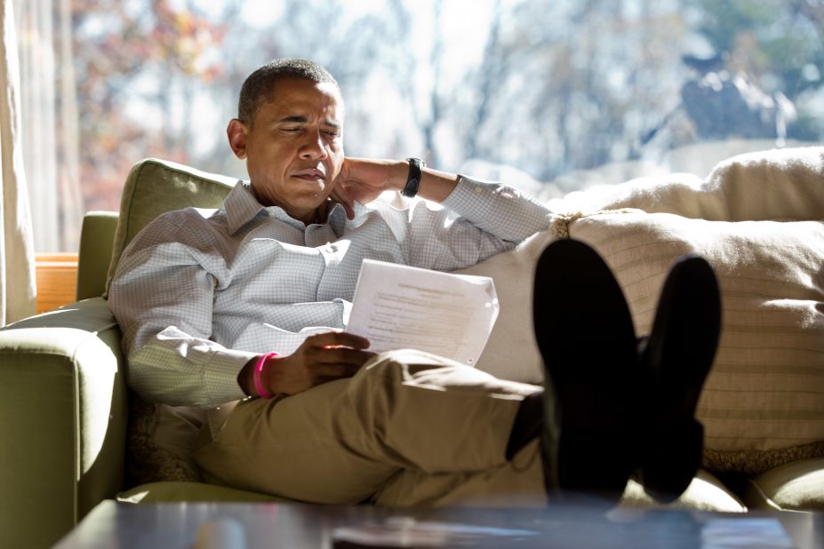 Obama reads briefing material while meeting with advisers inside his cabin on Sunday, October 21, at Camp David, Maryland. 
